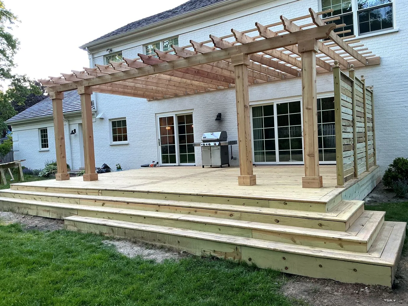Custom pergola over a raised hardwood deck with grill station