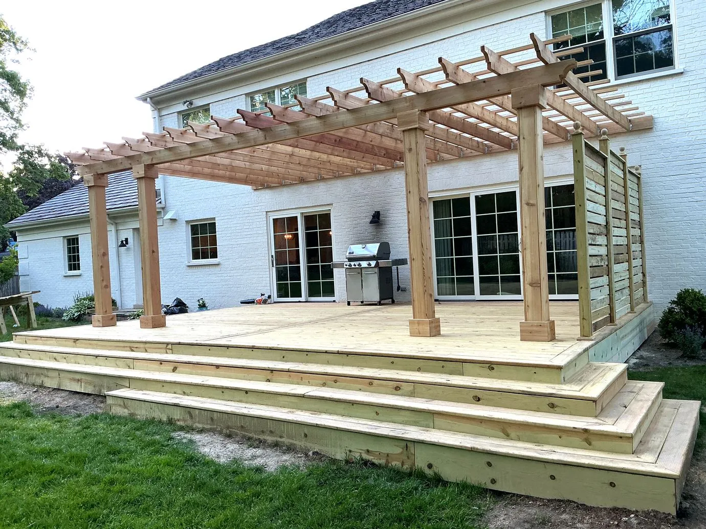 Pergola and deck at dusk with privacy screen