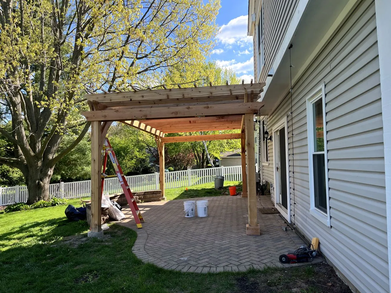 Pergola over a herringbone paver patio